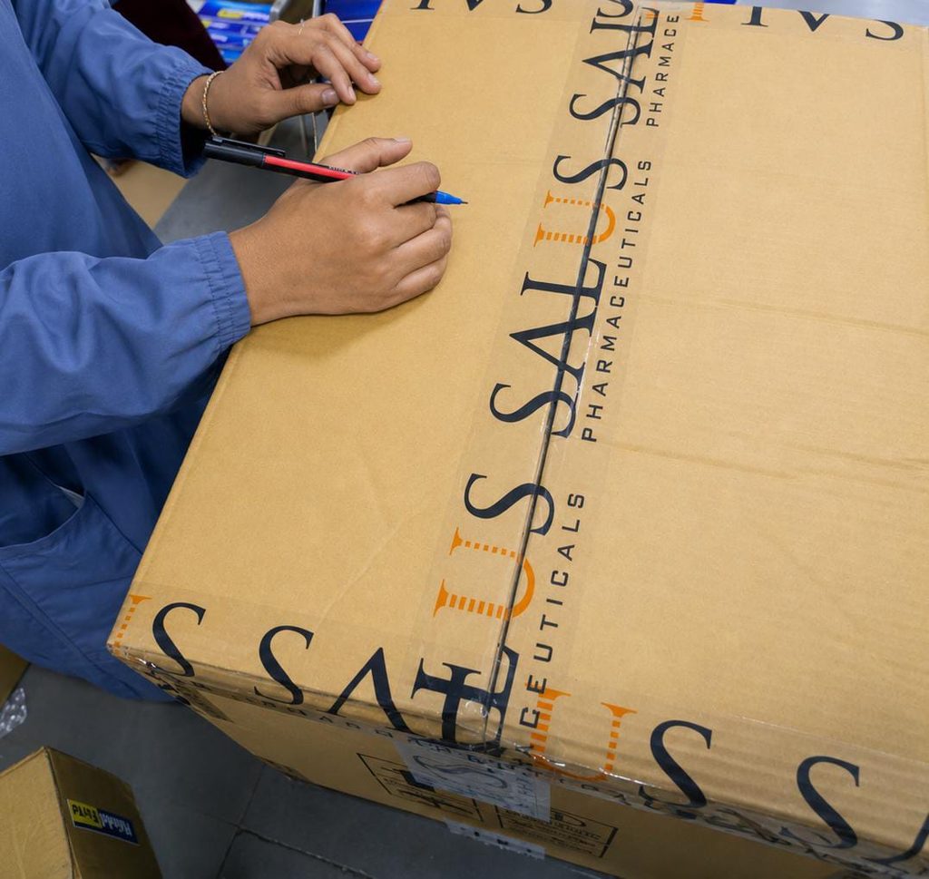 Female worker handling boxes on the pharmaceutical manufacturing floor